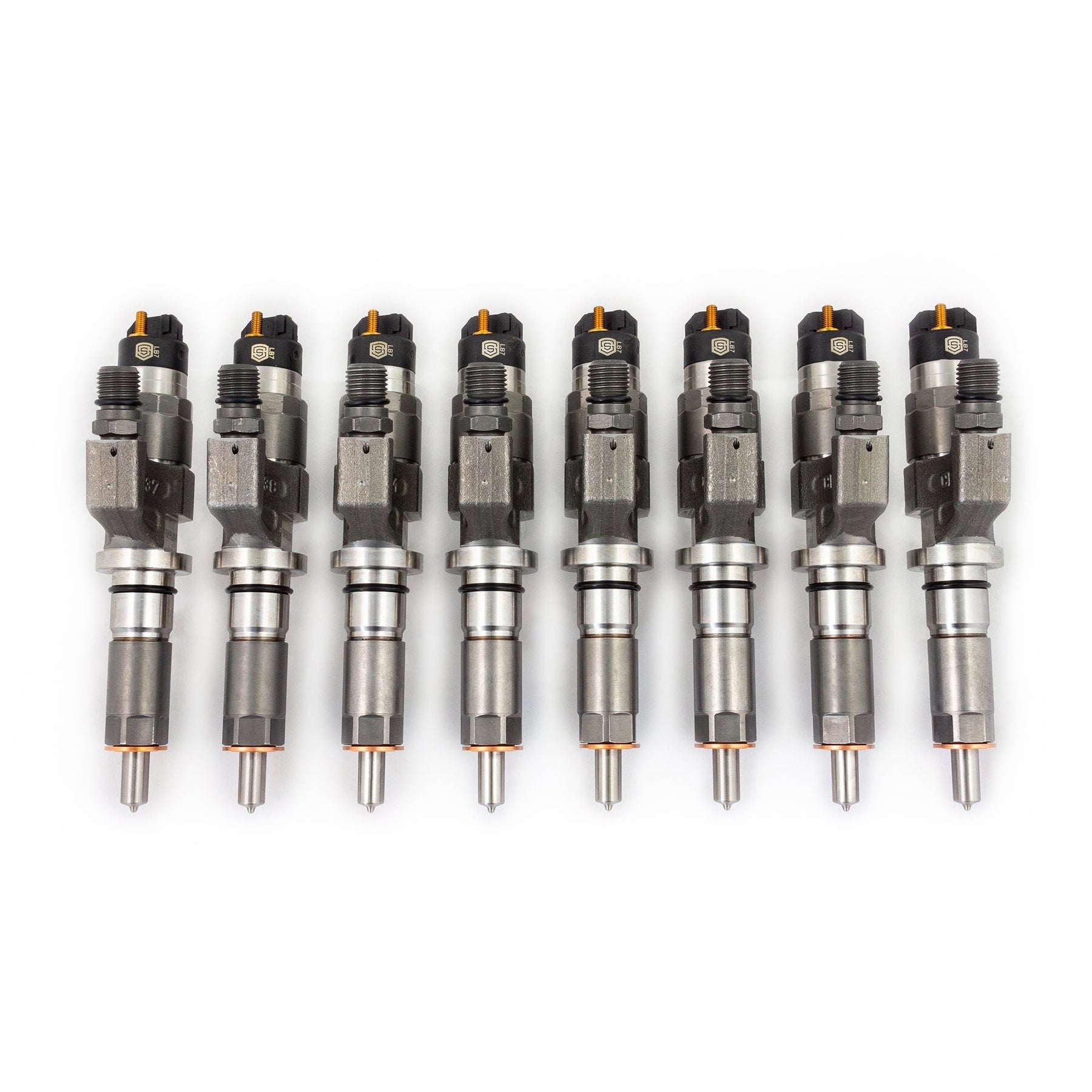 Complete set of eight LB7 Duramax fuel injectors with orange caps, lined up showing nozzle tips and top connectors